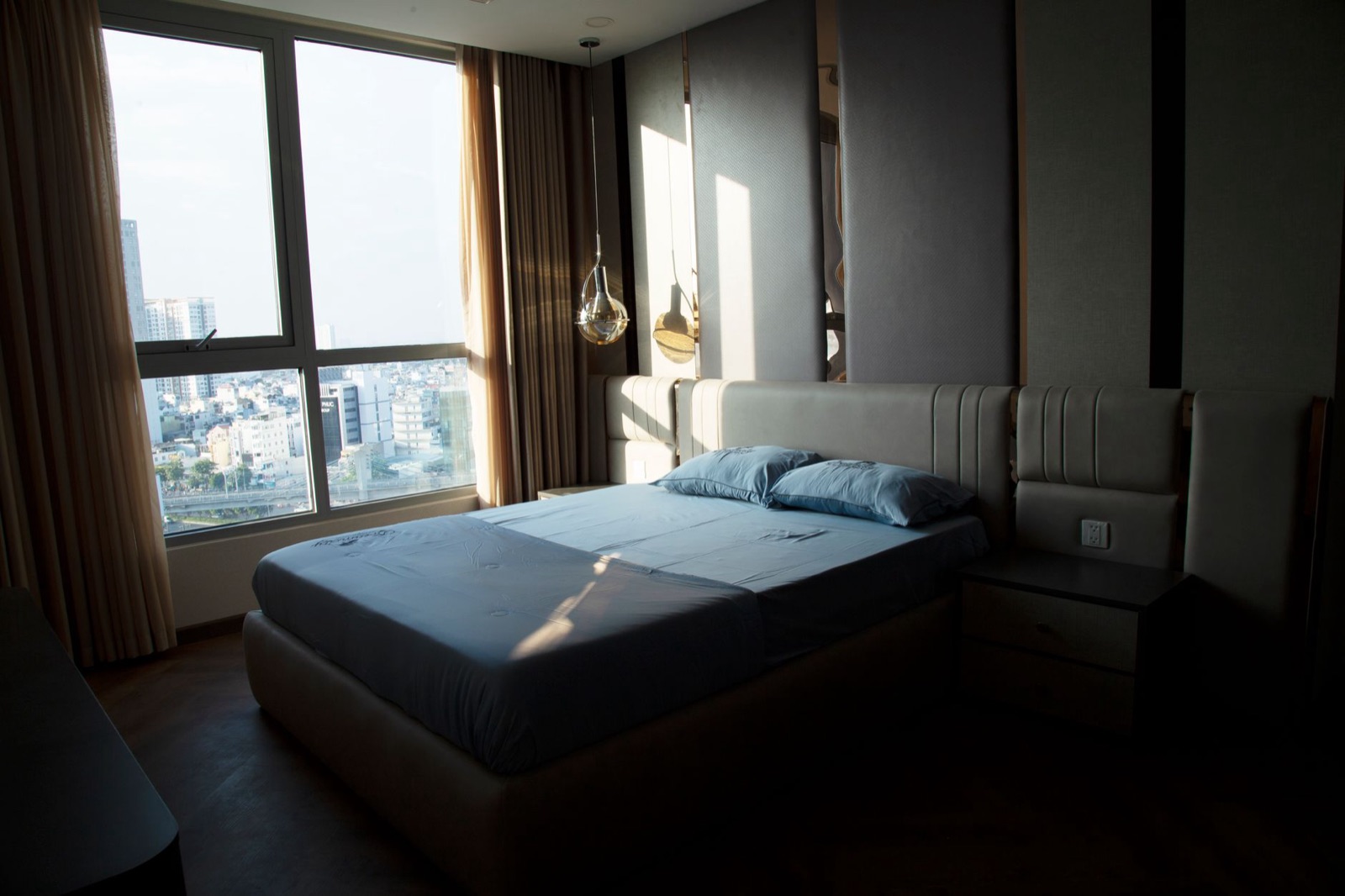 Bedroom with a wall of windows high above the city