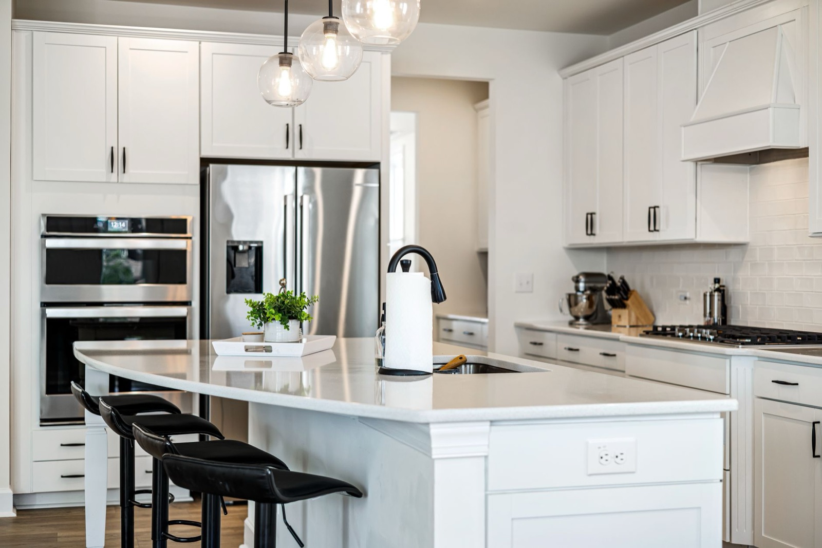 White kitchen with globe pendants and a breakfast island