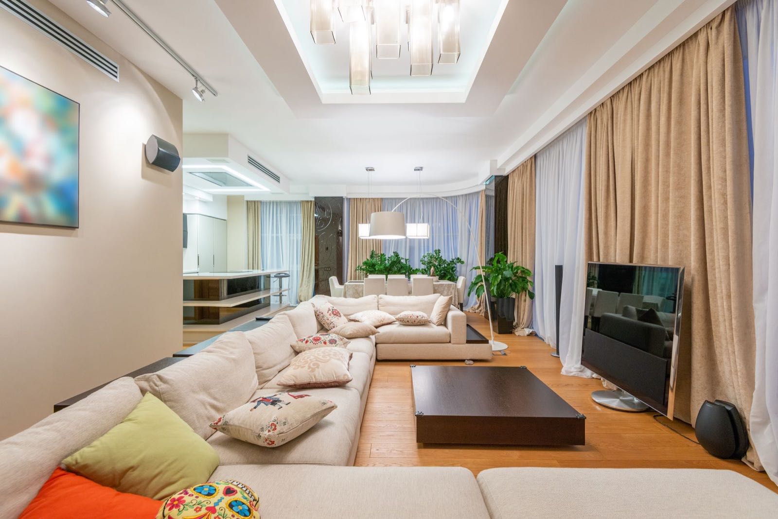 Sectional sofa and glass pendants in a muted living room