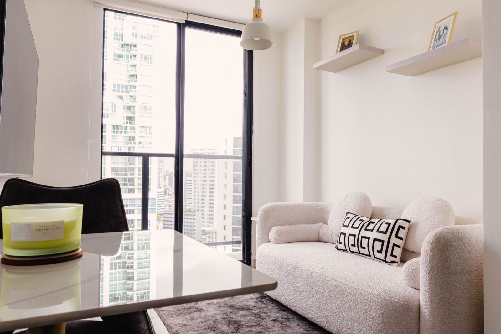 Compact lounge with a floor-to-ceiling window onto high-rise towers