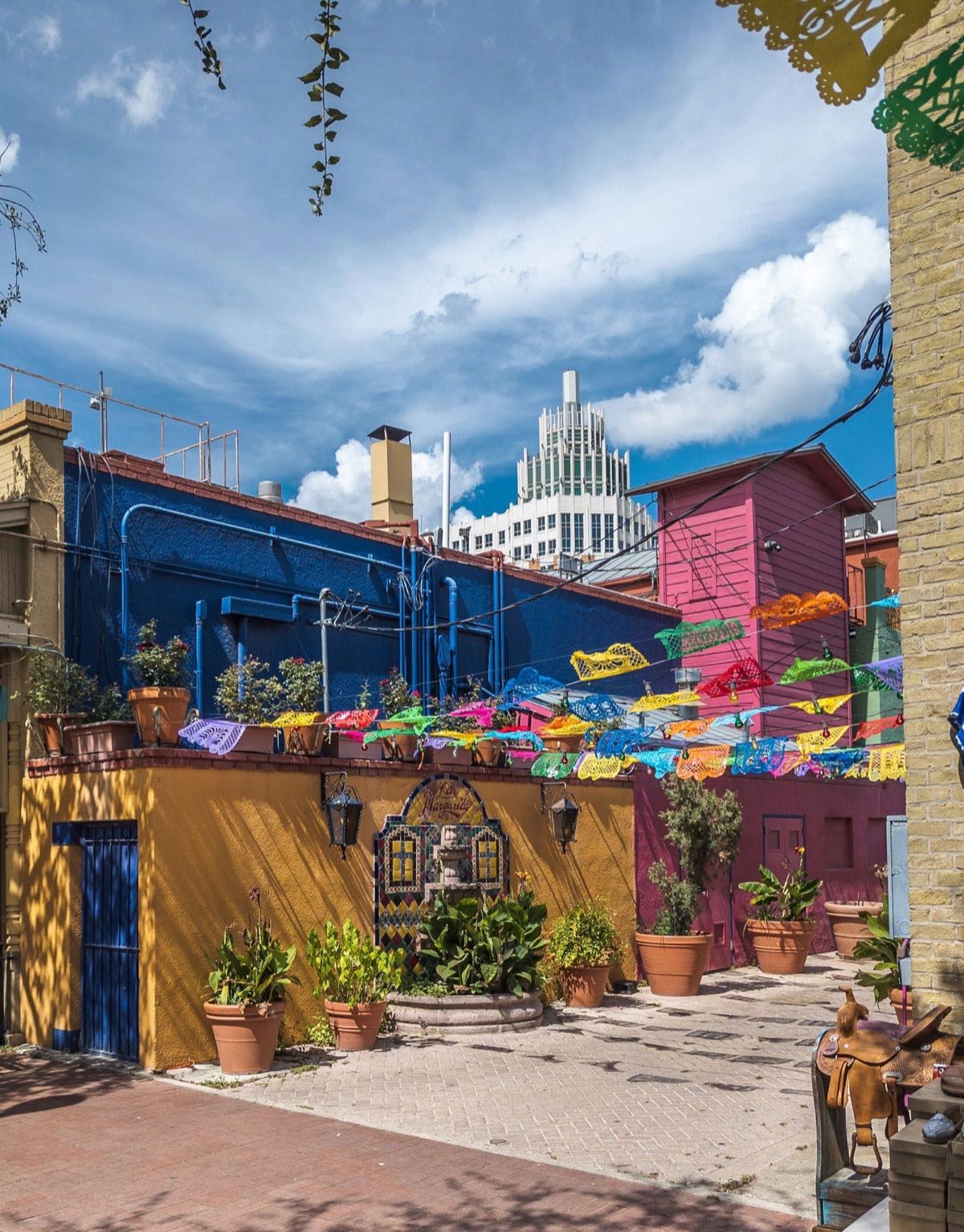 Papel picado banners strung over a market courtyard in San Antonio