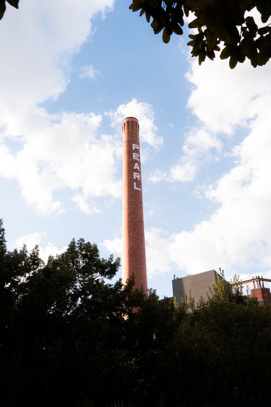 The brick Pearl smokestack above the treeline in San Antonio