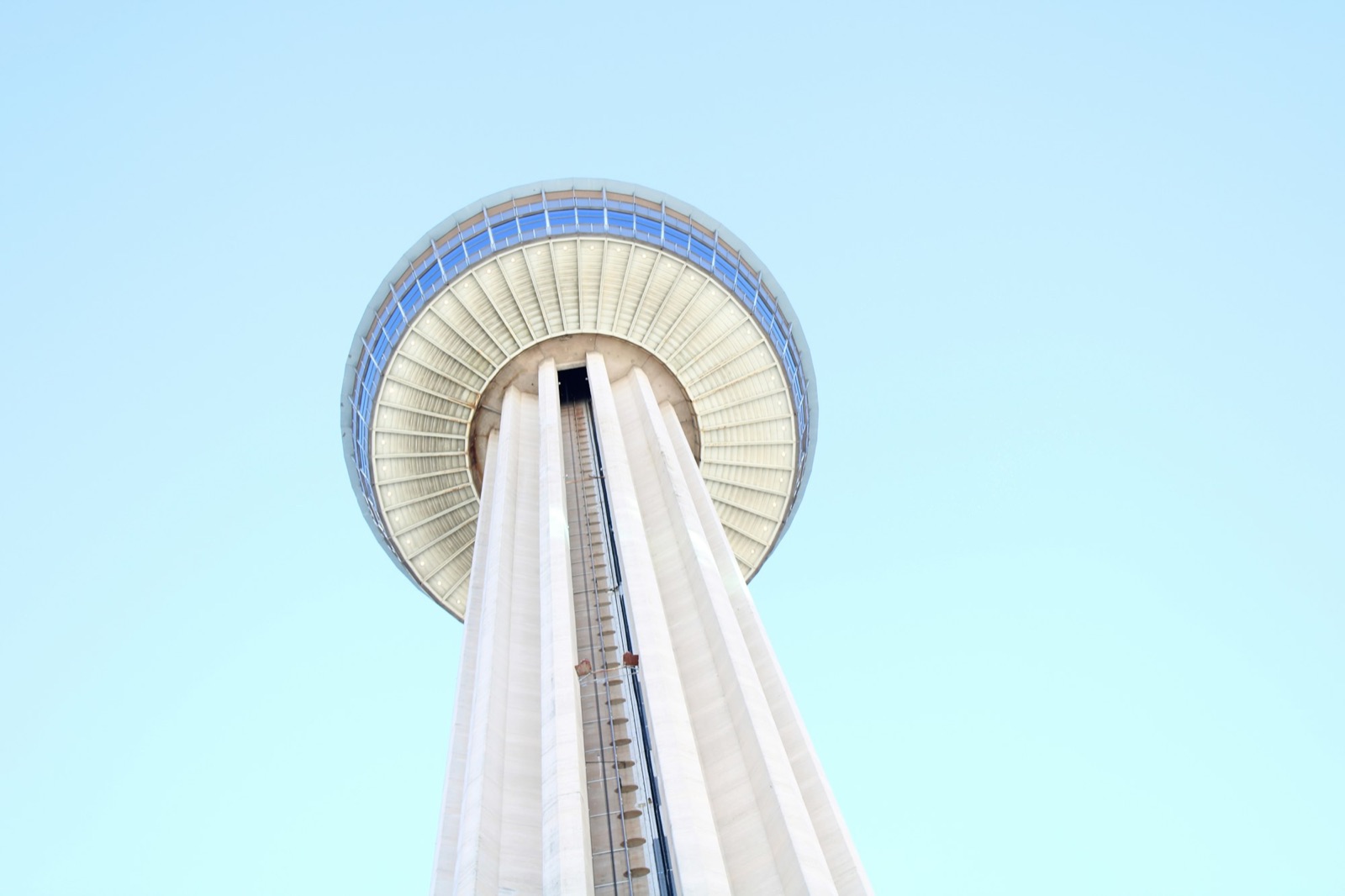 Looking up the shaft of the Tower of the Americas against a pale sky