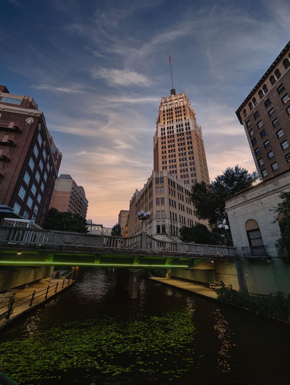 The Tower Life Building rising over the San Antonio River at dusk
