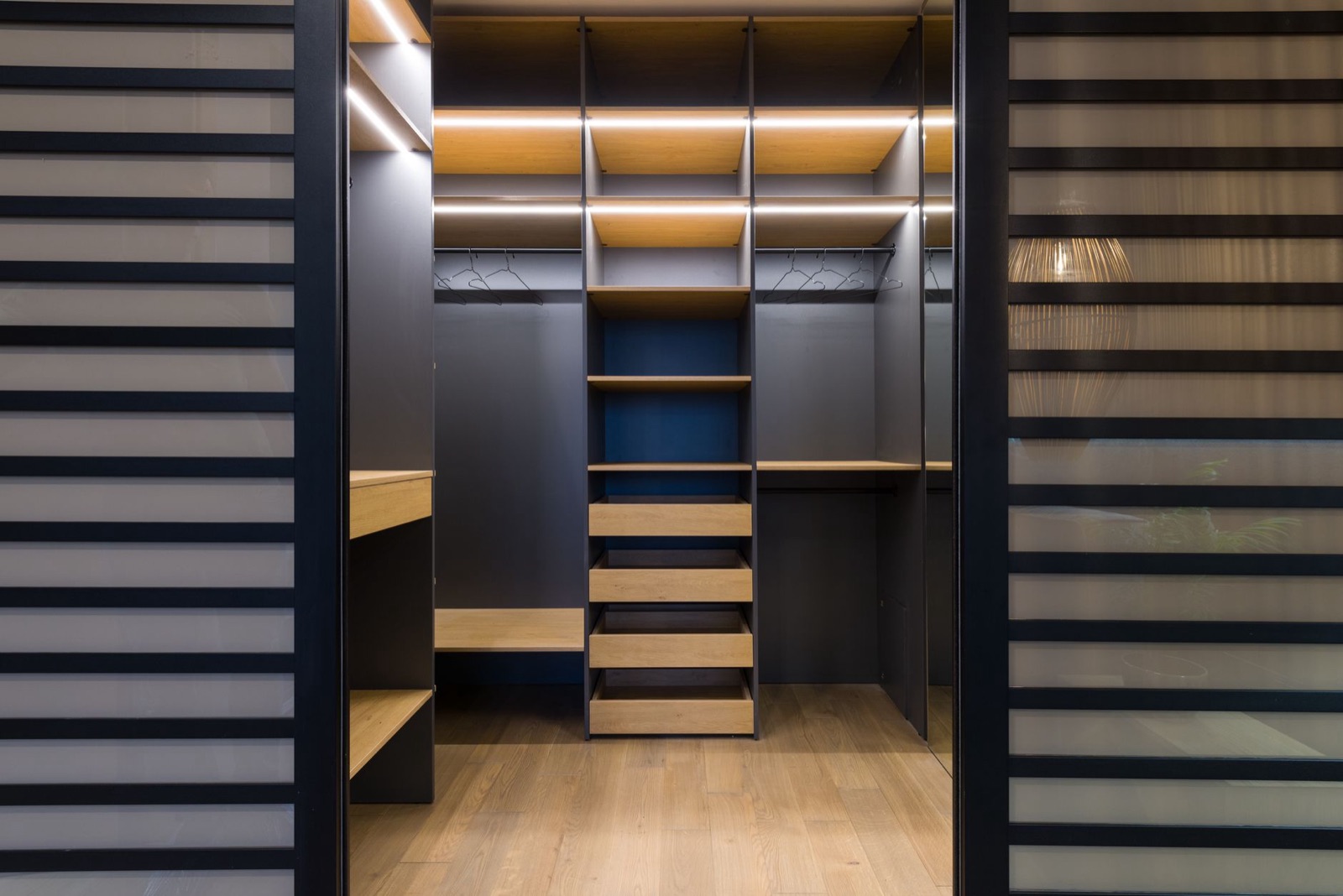 Fitted walk-in closet with lit shelving